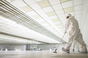 „Größte Halbleiterfabrik Europas“: Wie die Milliardeninvestition von Infineon in Dresden dem Land Hoffnung machen soll - Reinigungskräfte säubern auf der Baustelle für das neue Infineon-Werk im zukünftigen Reinraum den Boden.