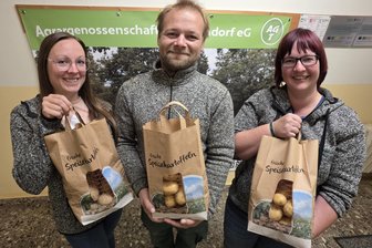 Größter Kartoffelproduzent im Vogtland: Das kosten die Erdäpfel in diesem Jahr - Jenny Gerbeth (links), Stephan Kaute und Henriette Meinel von der Agrargenossenschaft Tirschendorf zeigen Kartoffeltüten, wie sie im Hofladen verkauft werden.