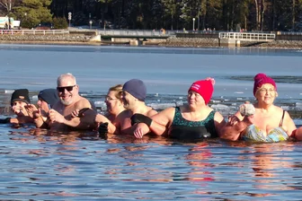 Großes Eisbaden im Erzgebirge: Was Wigald Boning mit dem 1000. Badetag einer Unternehmerin zu tun hat - Anke Bergelt und Sabine Schubert, die beiden Frauen hinter der Idee des Bade-Jubiläums, sind an ihren roten Mützen in der badenden Menge gut zu erkennen.