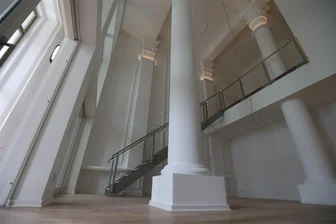 Großes Foyer, Stuck an den Decken und Säulen im Wohnzimmer: So wohnt es sich im früheren Kulturpalast Rabenstein - Säulen, meterhohe Glasfronten und Stuck: Blick in den Wohn- und Kochbereich einer der Wohnungen im historischen Kulturpalast-Gebäude.