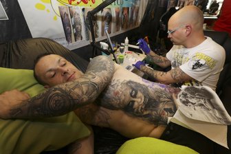 Großes Stechen in der Plauener Festhalle: Tattoo-Convention - Micha lässt sich von Marcel Rabe, dem Inhaber des Studios Colour your Life in Plauen, ein weiteres Tattoo stechen.
