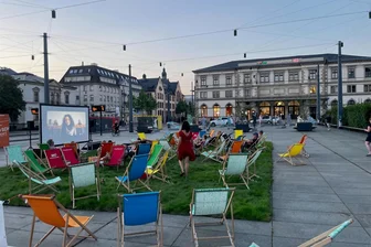 Grün statt grau: Verein rollt Wiese auf dem Chemnitzer Bahnhofsvorplatz aus - Am Freitagabend sind die ersten Liegestühle bereits besetzt gewesen.
