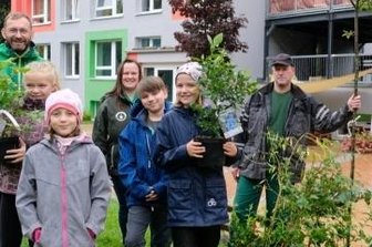 Grüne Spende für die Kinderarche - Marko Hofmann von Fielmann; Bianca Beyer, stellvertretende Einrichtungsleiterin des Naturhortes, Jörg Schöne von der Gärtnerei Schöne (hinten v. l.) freuen sich mit Zoe, Chiara, Jonas und Maria (vorn v. l.) über das neue Grün.