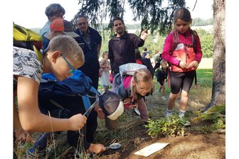 Grundschüler besuchen Ameisen-Großstadt in kleinem vogtländischen Wald - Ameisenheger Thomas Müller (hinten rechts) führte die Kinder vorsichtig an den Hügel heran.