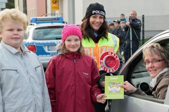 Grundschüler blitzen Verkehrsteilnehmer in Pockau - Alexander Nebe, Hanna Schönherr und Polizeiobermeisterin Doreen Jarsky überreichen Annett Börner ein kleines Dankeschön für umsichtiges Fahren.