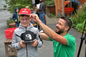 Grundschule Oberschöna: Wie sicher ist der Schulweg? - Oskar von der Klasse 1 b der Grundschule Oberschöna freute sich am Dienstag, als ihm Marko Bräuer von der Gebietsverkehrswacht Freiberg, zugleich Leiter der Dekra-Außenstelle Freiberg, ein rotes Basecap aufsetzte.