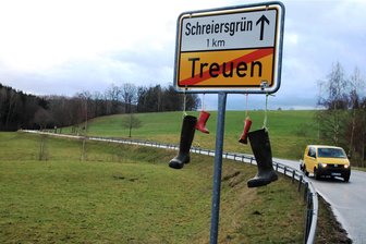Gummistiefel als Bauernprotest in Treuen - Am Treuener Ortsausgangsschild hängen kleine und große Gummistiefel.