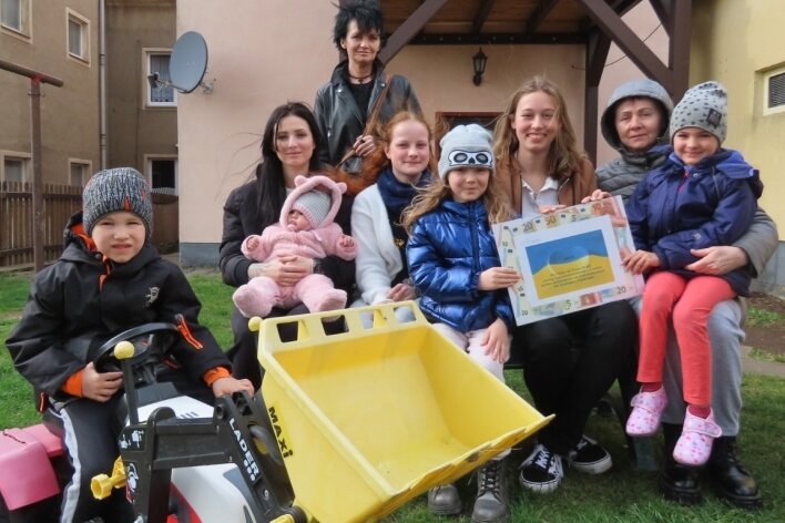Gymnasiasten backen als Hilfe für Geflüchtete - Nathalie Hilkman (Bildmitte, links) und ihre Klassenkameradin Chiara Engelhardt (Mitte rechts) bei der Übergabe der Erlöse des Kuchenbasars an ukrainische Kinder und deren Mütter. 