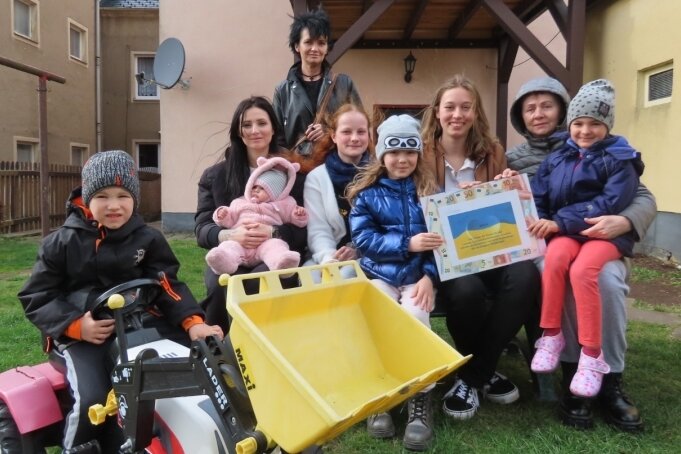 Gymnasiasten backen für Geflüchtete - Nathalie Hilkman (Bildmitte, links) und ihre Klassenkameradin Chiara Engelhardt (Mitte rechts) bei der Übergabe der Erlöse des Kuchenbasars an ukrainische Kinder und deren Mütter. 