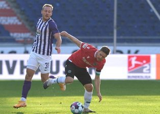            Hannovers Dominik Kaiser (r) und Ben Zolinski von Erzgebirge Aue kämpfen um den Ball.