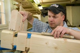 "Häuslebauer" mit vollen Auftragsbüchern - In der Firma Blockhausbau Frank in Kleinhartmannsdorf fertigt Mitarbeiter Thomas Fischer gerade Balken für die Innen- und Außenwände. Der Facharbeiter für Werkzeug und Maschinen ist seit 1995 im Betrieb.