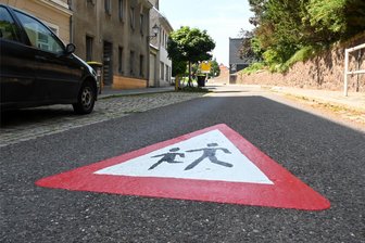 Hainichen: Bahnhofstraße nun wieder frei, Marktstraße nur für Fußgänger - Das erneuerte Piktogramm "Achtung Kinder" auf der Bahnhofstraße in Hainichen vor der Kita.