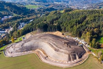 Halbzeit auf Großbaustelle "Knochen" - Diese Drohnenaufnahme aus der Luft zeigt den aktuellen Stand der Haldensanierung und die erkennbare, neue Profilierung des "Knochens" in Raschau-Markersbach. Seitlich an der Halde ist bereits das neue Regenrückhaltebecken zu sehen, ebenso wie die begonnene Umfahrung.