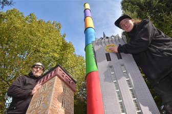 Halloween im Miniaturpark Oederan: Wo Mitmachen ausdrücklich erwünscht ist - Hoch hinaus will man auch in der Miniaturschauanlage Klein Erzgebirge, wenn Kulturhauptstadt 2025 gefeiert wird. Selina Siegel (r.) am Turm des Wirkmaschinenbaus und Oliver Weinhold mit dem Roten Turm vor Karli, der Chemnitzer Esse.