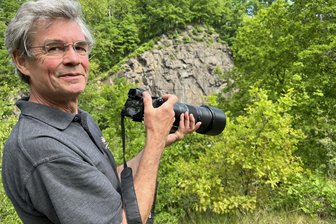 Halsbrücke: Mit Teleobjektiv Wanderfalken bei der Aufzucht beobachtet - Jürgen Weyer mit seiner Kamera. Im Hintergrund die „Russenwand“ bei Halsbrücke, in der Wanderfalken ihren Nachwuchs großziehen.