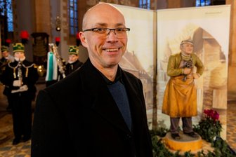 Hammer-Hansl, ein unvergessenes Original: Annaberger Krippenweg bekommt neue Figur - Der Schöpfer und sein Kunstwerk: Holzbildhauer Ronny Tschierske vor der Hammer-Hansl-Figur während der Präsentation in der Annenkirche.