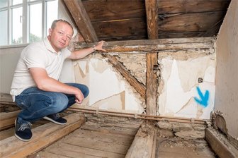 Handwerker sind im Urlaub: Großrückerswalde muss Umbauarbeiten in Grundschule verschieben - Im zweiten Obergeschoß zeigt Thomas Hermann Schäden an Dachbalken, Ständerwerk und Deckenbalken, die in den ehemals als Wohnung genutzten Räumen entdeckt wurden.