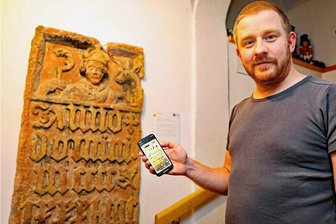 Handy-Nutzung im Werdauer Museum ist ausdrücklich erwünscht - Markus Döscher demonstriert am Egidienstein aus dem Jahr 1480 den neuen Audio-Guide. An insgesamt 16 Stationen erfahren die Besucher Wissenswertes über die Geschichte der Stadt Werdau.