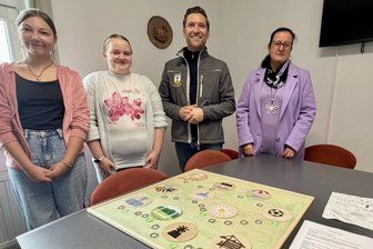 Hartmannsdorfer Klöppelkids gewinnen mit Spielidee 1. Preis bei Klöppelkongress - Vanessa Philp und Vanessa Geppert, Bürgermeister Christfried Nicolaus und Klöppellehrerin Susan Schramm präsentieren das Spiel.