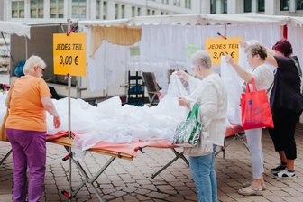 Hauptsache billig: Was der Chemnitzer Schlüpfermarkt mit der Toskana zu tun hat - Typische Schlüpfermarktszene in Chemnitz: Seniorinnen am Wühltisch mit Gardinenstoffen.