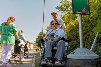 Hecke versperrt in Rodewisch Rolli den Weg - Die Hecke und wuchtige Haltestellenaufsteller sorgen dafür, dass Heinz Hammer mit der im Rollstuhl sitzenden Ehefrau Marlies (rechts) nicht den Fußweg passieren kann. Dann muss er auf die Parkstraße ausweichen, wie es auch die Alltagsbegleiterinnen vom K & S-Heim oft tun. 