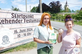 Heimatfest in Grünhainichen: Das sind die Höhepunkte an diesem Wochenende - Hier beginnt am Sonntag der stehende Festumzug in Waldkirchen. Die von Sindy Franke (links) und Jenny Meding präsentierten Karten und Bierdeckel, auf denen die Aufgaben der 18 Stationen abgehakt werden können, sind dabei von großem Nutzen.