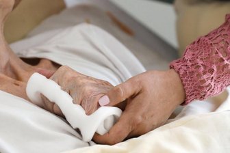 Heimplatz droht unbezahlbar zu werden: Bringt die Pflegereform Entlastung? - Eine Pflegeschwester hält die Hand einer alten Heimbewohnerin. Heimbewohner im Erzgebirge und ihre Angehörigen fürchten, sich das bald nicht mehr leisten zu können.