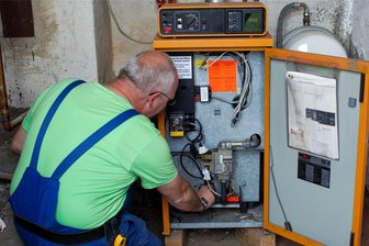 Heizungsgesetz: Das sind die neuen Vorgaben - Geht da noch was zu optimieren? Ein Heizungsmonteur kontrolliert eine ältere Anlage.