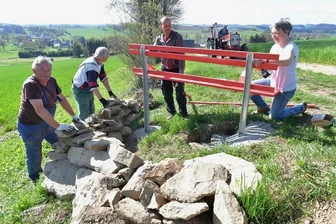 Helbigsdorfer Verein sorgt für schöne Ausblicke - Am Müdisdorfer Weg in Helbigsdorf legten Roland Neubert, Jörg Baumgart, Ralf Ahrens und Katrin Weigold (v. l.) einen Aussichtspunkt über Helbigsdorf an. Das Bankgestell wurde fest einbetoniert, dann die Latten angeschraubt und der Platz mit Feldsteinen befestigt.