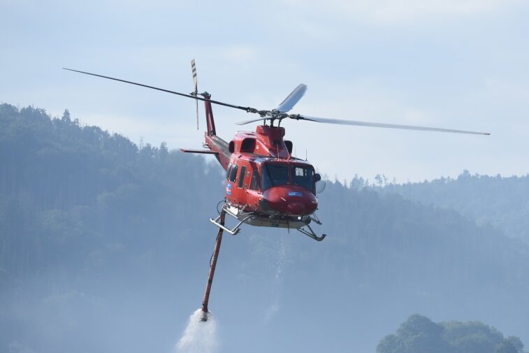 Helfer im Hubschrauber: Wie Piloten den Waldbrand in der Sächsischen Schweiz bekämpfen - Ein Löschhubschrauber steigt nach dem Wassertanken im Elbtal auf.
