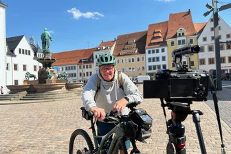 Helm, Kamera und Heimatgefühl – dieser Filmer zeigt das Erzgebirge vom Rad aus - Film- und Radprofi Uwe Mann auf dem Obermarkt in Freiberg.