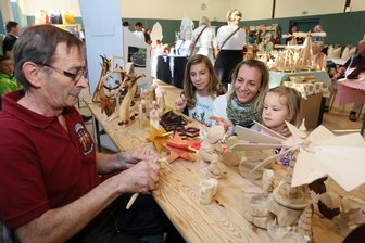 Herbstfest in Mülsen: Vereine und Händler locken Tausende Gäste - Kathleen Oehmig beobachtete mit ihren Kindern Leonie und Toni Dieter Rochow beim Schnitzen.