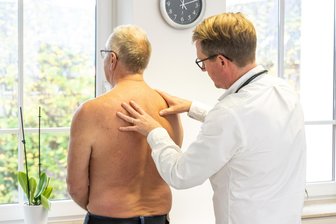 Hexenschuss, Grippe, Norovirus zwischen den Jahren: Wohin zum Arzt in Mittelsachsen? - Ein Arzt tastet den Rücken eines Patienten ab.