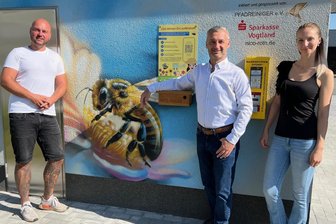 Hier steht der erste Bienenfutter-Automat im Vogtland - Suzan Leonhardt (r.) und Nico Roth (l.) von den Pfadreinigern mit Adorfs Stadtchef Rico Schmidt.