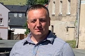 Hilfe für Retter in zwei Orten - Bad Brambachs Bürgermeister Maik Schüller mit dem Defibrillator am Feuerwehrhaus Schönberg.
