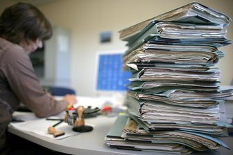 Hilferuf an von der Leyen - Ein Stapel Akten liegt auf einem Schreibtisch.
