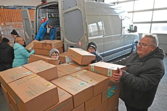 Hilfsprojekt: Erzgebirger schicken Kuscheltiere, Schulmaterial und Süßigkeiten auf Reise - Wesley und Matthieu Cordes haben Frank Richter (v. l.) beim Entladen der Päckchen aus Flöha geholfen.