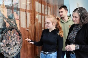 Hingucker im Schulzentrum: Kunst von Hans Brockhage - BSZ-Schulleiterin Caterina Martin (r.) sieht sich mit der Dorfchemnitzerin Lorena Weidlich (20), die im 3. Ausbildungsjahr zur Kauffrau für Büromanagement ist, und dem Crandorfer Max Gräßler (17) aus der Klasse 12 der Fachoberschule die wieder aufgebaute "Brockhage-Wand" an.