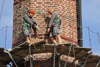 Historische Esse nach Verjüngungskur fast wie neu - Die Arbeit auf dem schmalen Konsolgerüst ist nicht ungefährlich. Mit Sicherheitsgurten schützen sich die Männer gegen Absturz. 
