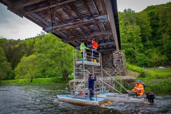Historische Holzbrücke Hennersdorf: Jetzt gibt es einen Termin für die Sanierung - Im Frühjahr 2021 wurden von einem schwimmenden Gerüst aus die Sensoren an der Holzbrücke montiert, die eine Überlastung erfassen. Jetzt gab es wieder eine Brückeninspektion.