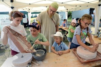 Historische Kinderfreizeit in Reumtengrün - Ein historisch gewandeter Daniel Arnstadt blickte Lilly, Linus, Pino und Jamie (v.l.) beim Backen über die Schultern.