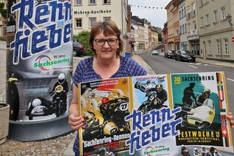 Historische Plakate werben für 95 Jahre Sachsenring - Ute Weißbach, Geschäftsführerin des Fremdenverkehrsvereins, mit dem neu gestalteten Plakat. Das Sammlerstück wurde in einer Auflage von 250 Stück geordert und ist für 2,50 Euro erhältlich.
