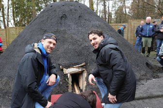 Historischer Meiler schwelt im Erzgebirge an der Köhlerhütte - Kevin Roch (l.) und Sebastian Paraschiv entzündeten gemeinsam mit dem Köhlerliesel den Meiler.