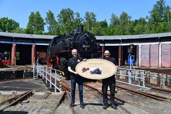 Historisches Adorfer Bahnbetriebswerk gehört jetzt zur Dampfbahn-Route Sachsen - Christian Sacher vom Projekt Dampfbahnroute Sachsen hat ein Stationsschild an Maik Pester vom Vogtländischen Eisenbahnverein Adorf übergeben.