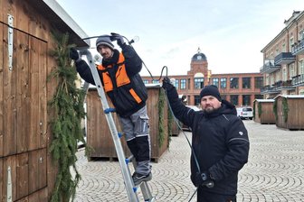 Historisches Ereignis in Flöha: Der erste Marktplatz in der Stadtgeschichte ist fertig - Claudius Müller (l.) und Ronny Hengst von der einheimischen Firma Elektro-Krause haben am Donnerstag vor Nikolaus die Buden mit Beleuchtung ausgestattet.