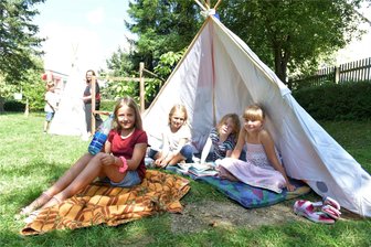 Hitzefrei? Wie Schulen und Kitas im Raum Freiberg auf die Affenhitze reagieren - Tipis als Schattenspender: Im Hort des Naturkinderhauses Mulda haben die Schüler gemeinsam mit Hortleiterin Bianca Beyer im Garten kleine Zelte aufgestellt. Emma, Enie, Emma und Lucy (v.l.) freuen sich darüber.