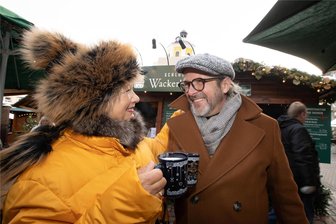Hoch die Glühwein-Tassen: So viel ist drin fürs Geld auf dem Plauener Weihnachtsmarkt - Jens Müller, der als Street-Art-Künstler „Tasso“ bekannt ist, wärmt sich auf dem Plauener Weihnachtsmarkt mit Marion Scholz bei einer Tasse Wackerbarth auf.