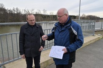 Hochwasser im Erzgebirge: Hat sich das Rückhaltebecken an der A 72 bewährt? Umweltminister auf Stippvisite - Umweltminister Wolfram Günther (l.) hat am Donnerstag mit Andreas Cramer, er ist der stellvertretende Geschäftsführer der Landestalsperrenverwaltung Sachsen, das Hochwasserrückhaltebecken Neuwürschnitz besucht.