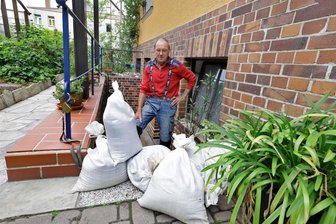 Hochwasser: Oberlungwitzer sind vorbereitet - und haben dennoch Angst - Konrad Schubert sichert den Kellereingang mit Sandsäcken. Vor Wasser, das durch den Kellerboden ins Haus gedrückt wird, kann er sich nicht schützen.
