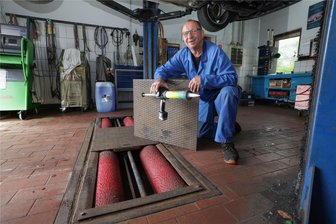 Hochwassergefahr in Glauchau-Niederlungwitz: Wie sich Anlieger wappnen - Gunter Vogel, Inhaber des gleichnamigen Autohauses, sichert seine Bremsprüfanlage mit Stahlplatten, die er mit Styropor abdichtet.
